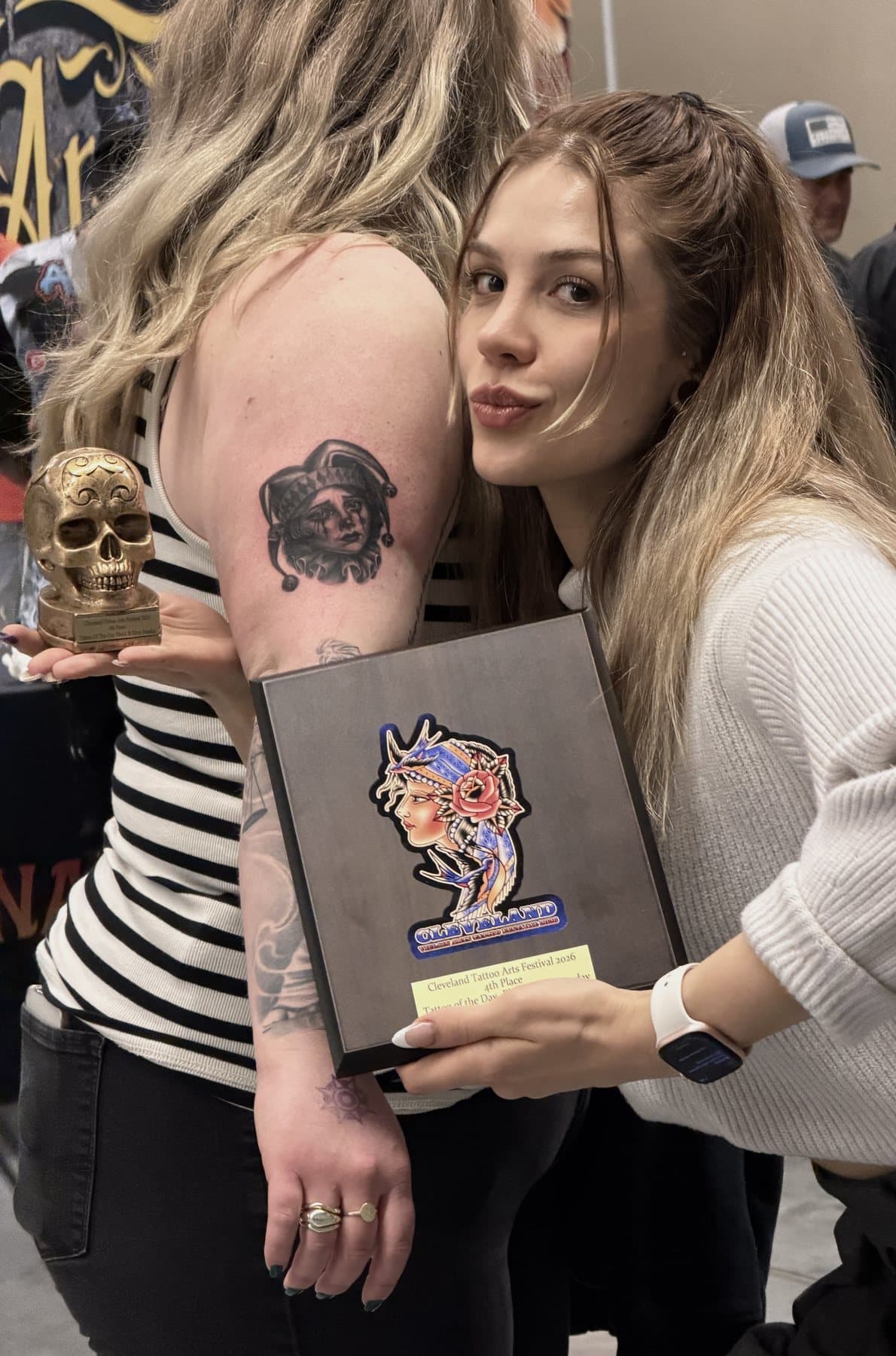 Aleyna Erkoc Atesli hugging her client and holding the Cleveland Tattoo Arts Festival 2026 plaque
