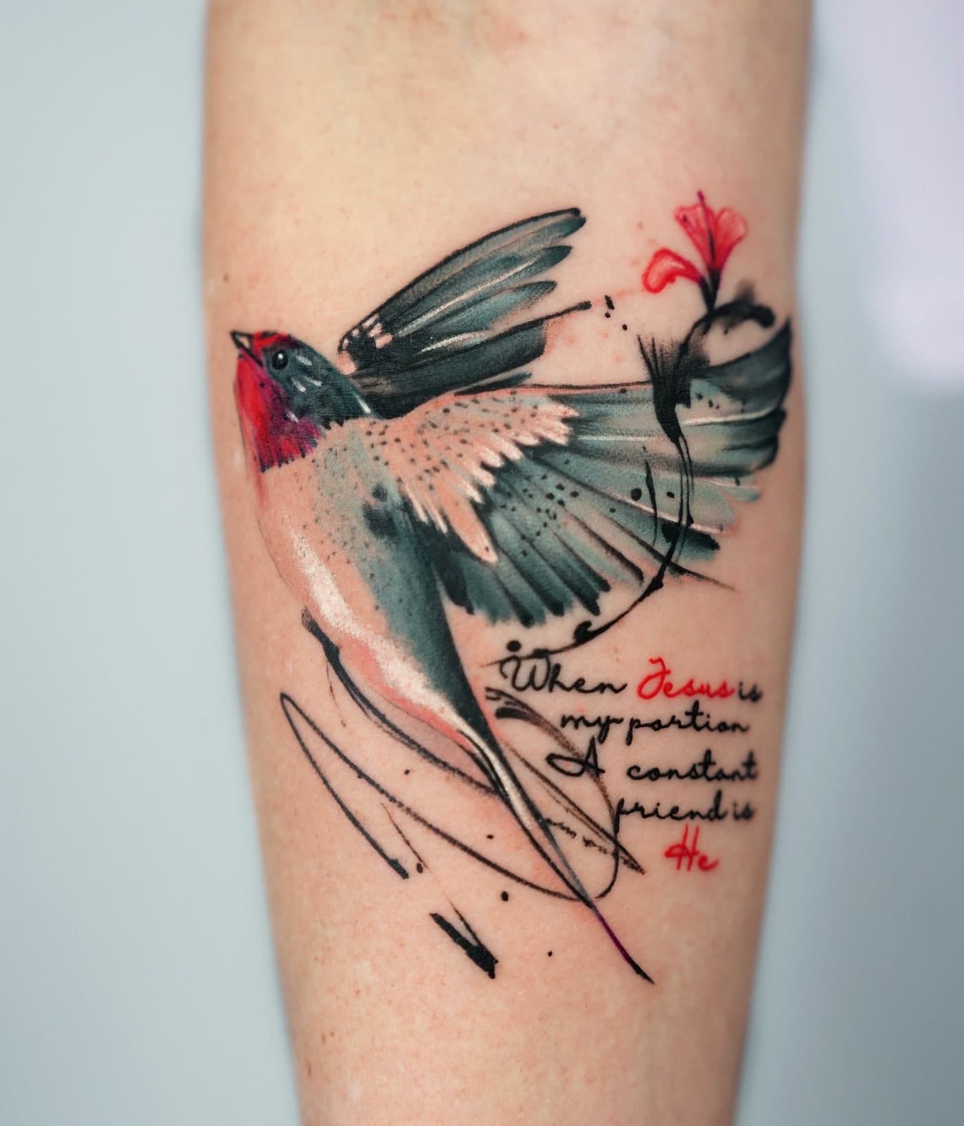 Painterly color tattoo of a swallow in flight with a red flower and handwritten script